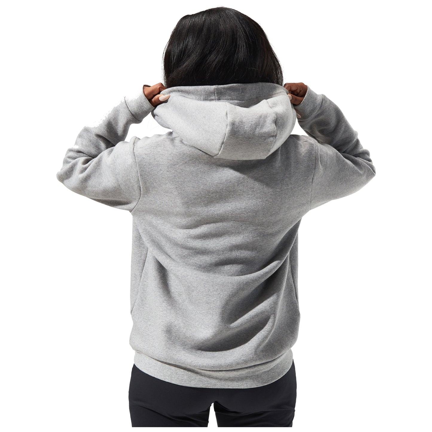 A person is adjusting the hood of a gray sweatshirt while facing away. The background is plain white, emphasizing the action and the clothing.