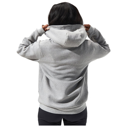 A person is adjusting the hood of a gray sweatshirt while facing away. The background is plain white, emphasizing the action and the clothing.