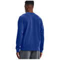 A person wearing a blue sweatshirt stands with their back facing the viewer, surrounded by a neutral background, suggesting a casual or relaxed setting.