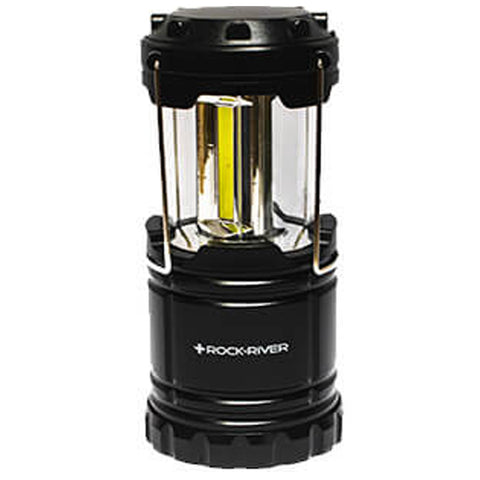 A black lantern stands upright illuminating its interior with a yellow light tube surrounded by clear glass panels in a neutral setting suitable for outdoor or emergency use