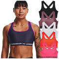 A woman with a tattoo wears a dark sports bra with purple accents while several other colored sports bras are displayed beside her in a bright and neutral background.