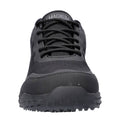 A black athletic shoe is centered in the image featuring a textured upper and a rugged sole designed for traction showcasing a logo on the tongue reading MAGNUM.