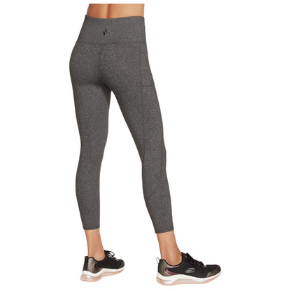Leggings are worn by a person who is facing away while standing in athletic shoes in a neutral setting designed for exercise or casual wear.