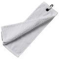 A white towel is hanging loosely and is slightly folded with a metal clip attached to one end resting against a flat surface providing a clean and functional appearance.
