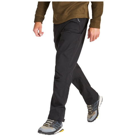 A person is walking while wearing black pants and gray hiking shoes the setting suggests an outdoor or active environment with the individual dressed for comfort and mobility.