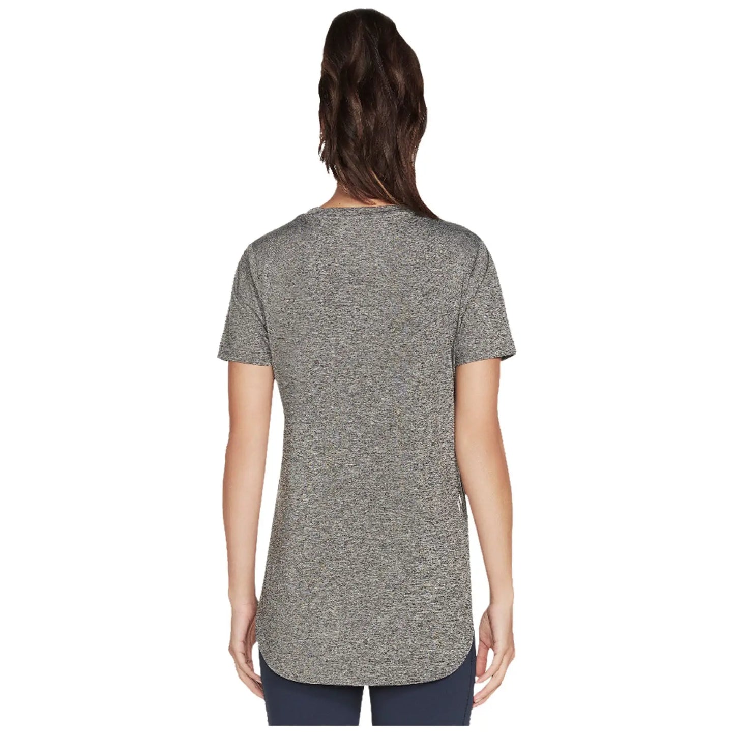 A person is standing with their back facing the viewer wearing a loose-fitting gray short-sleeve shirt that has a rounded hem in a neutral background.