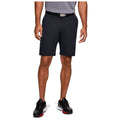 A man stands wearing dark shorts and a gray polo shirt with a black belt and black shoes on a white background, suggesting a casual or athletic setting.