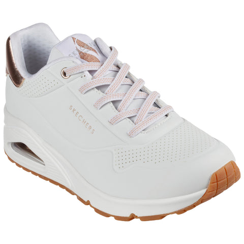 A white sneaker with light pink accents is positioned at a slight angle showcasing its perforated design and textured sole while displaying the brand name on the side