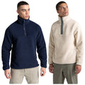 Two men wear different styles of fleece pullovers. One pullover is navy blue with a high collar and buttons while the other is cream colored with a contrasting button placket.