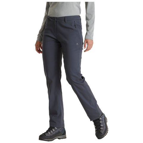 A person is wearing dark gray hiking pants and sturdy boots while standing with one leg slightly forward in a casual outdoor setting. The individual has a neutral expression and is dressed in a long-sleeved light gray top.
