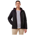 A woman stands confidently wearing a black padded jacket with a hood over a striped shirt in a neutral setting showcasing her relaxed yet stylish appearance.