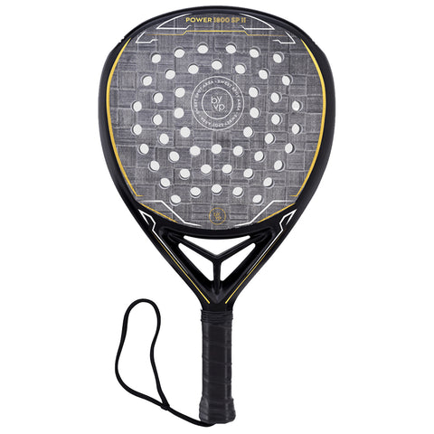 A padel racket features a solid black frame with a textured surface and holes for ball impact the grip has a black textured handle with a wrist strap for secure handling.