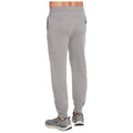 Grey sweatpants are worn by a person standing with their back towards the viewer wearing grey athletic shoes in a neutral indoor setting. A small pocket is visible on the back of the pants.